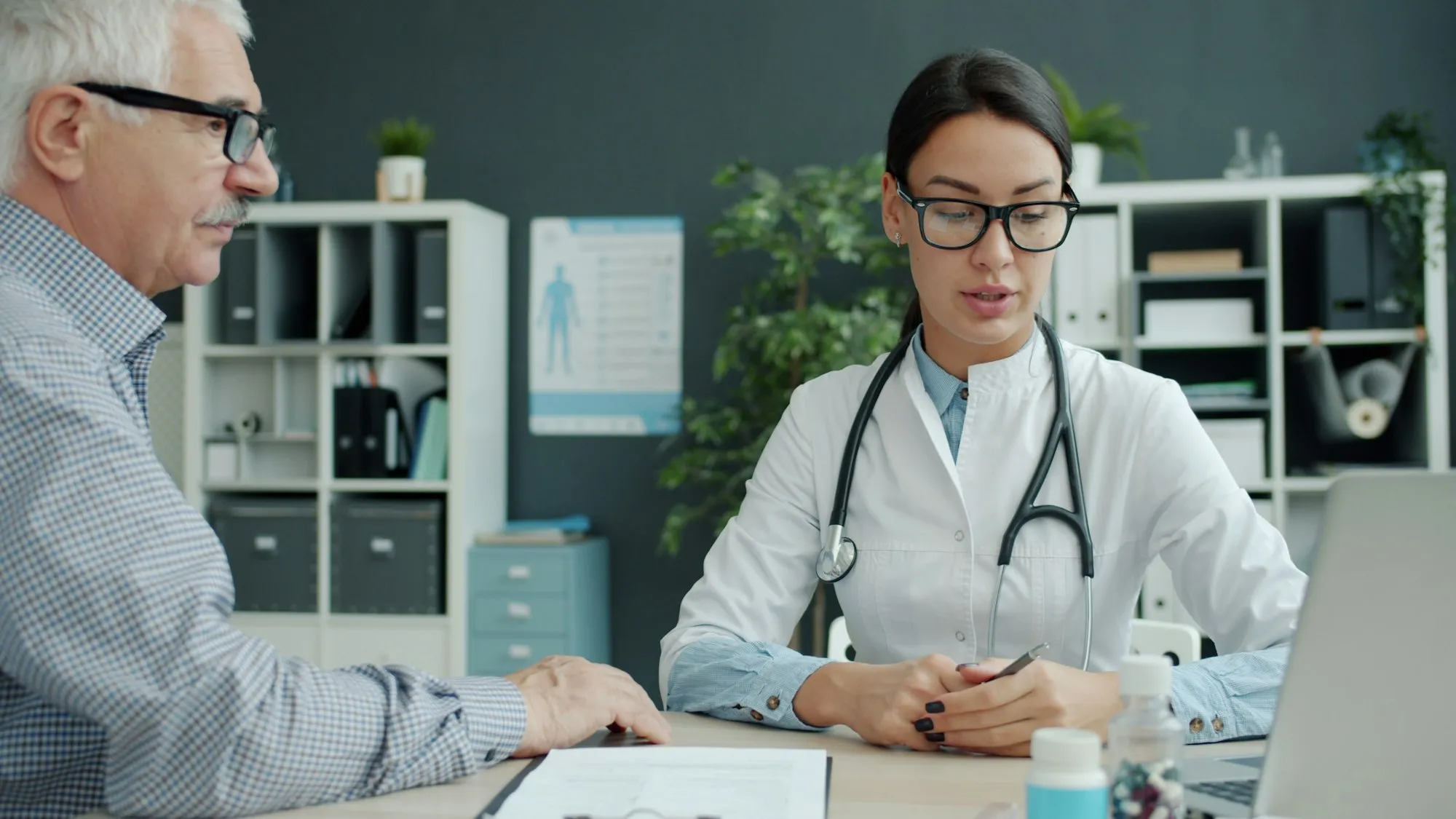 Ärztin im Gespräch mit einem älteren Patienten